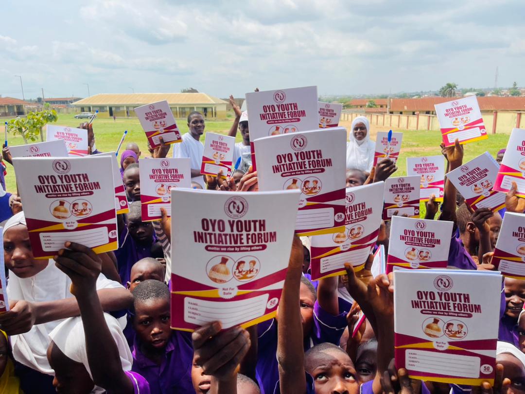 Schoolgirls holding up donated sanitary pads in a classroom